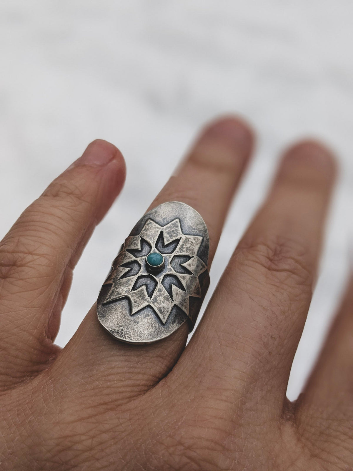 Sterling silver ring featuring lonestar quilt pattern and a small turquoise stone.