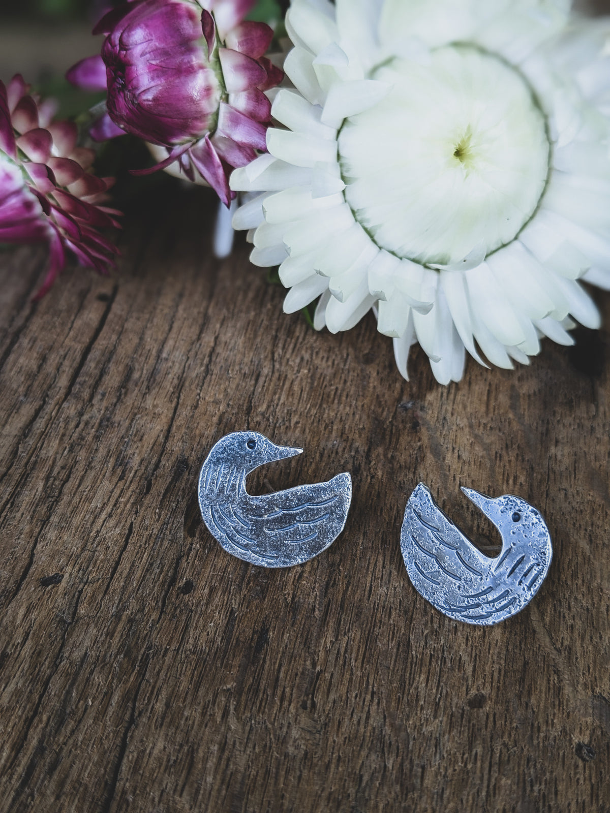 loon stud earrings made of sterling silver with stamping to give a folk art style
