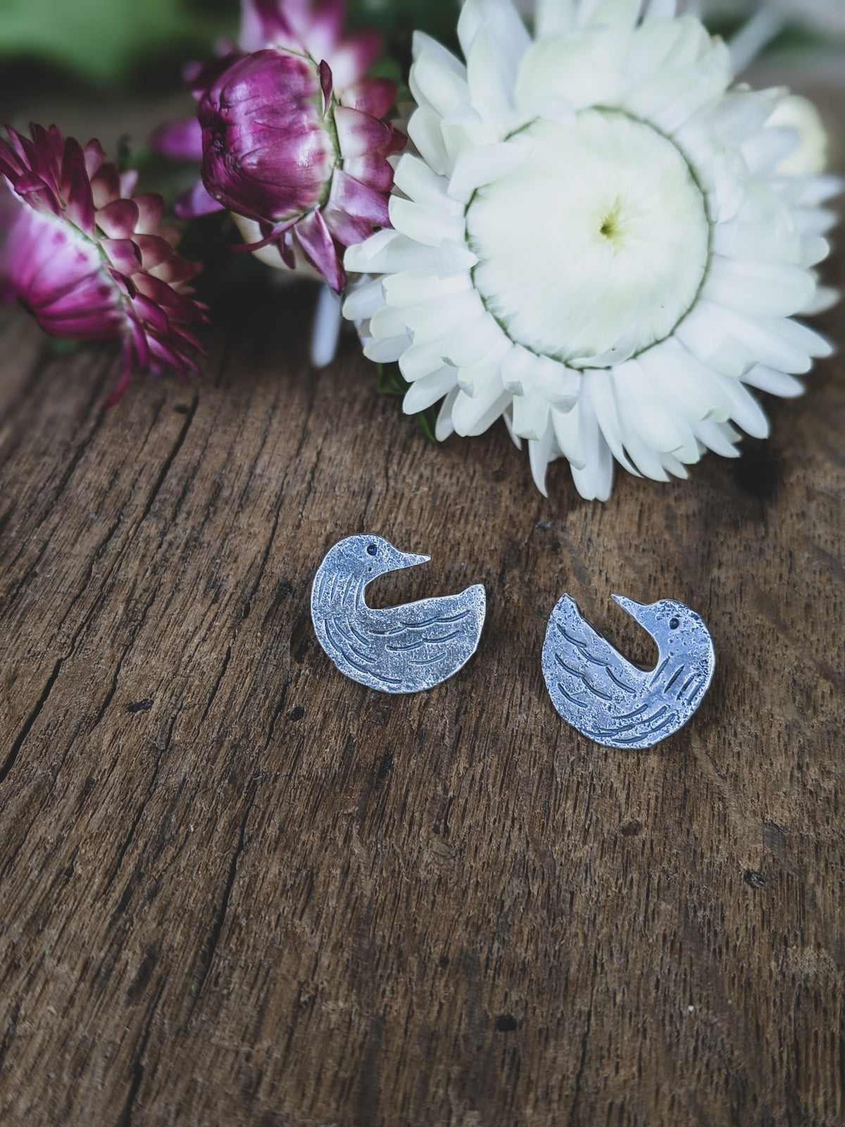 loon stud earrings made of sterling silver with stamping to give a folk art style